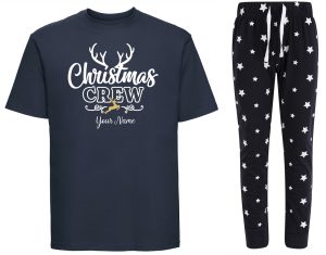 A navy printed t-shirt next to navy pyjama bottoms covered in stars. The print to the t-shirt is text that reads "Christmas Crew" and sample text "your name". The word: "Christmas" is in cursive solid white. The word "crew" is block capital outlines. The sample "your text" is in a solid white cursive font. Behind the word "Christmas" are white antlers reaching up. Between the texts "crew" and "your name" are two curley white lines with a golden reindeer betweem them.