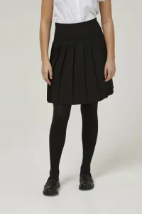 Frontal view of someone wearing a black premium stitch-down pleated skirt with a tucked-in white blouse and black tights.