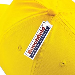 Close up view of a Beechfield tag on a yellow cap.