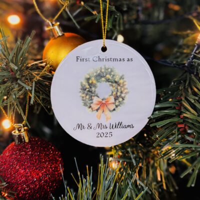 Photo of an example personalised ceramic Christmas decoration for newly weds hanging on a Christmas tree.