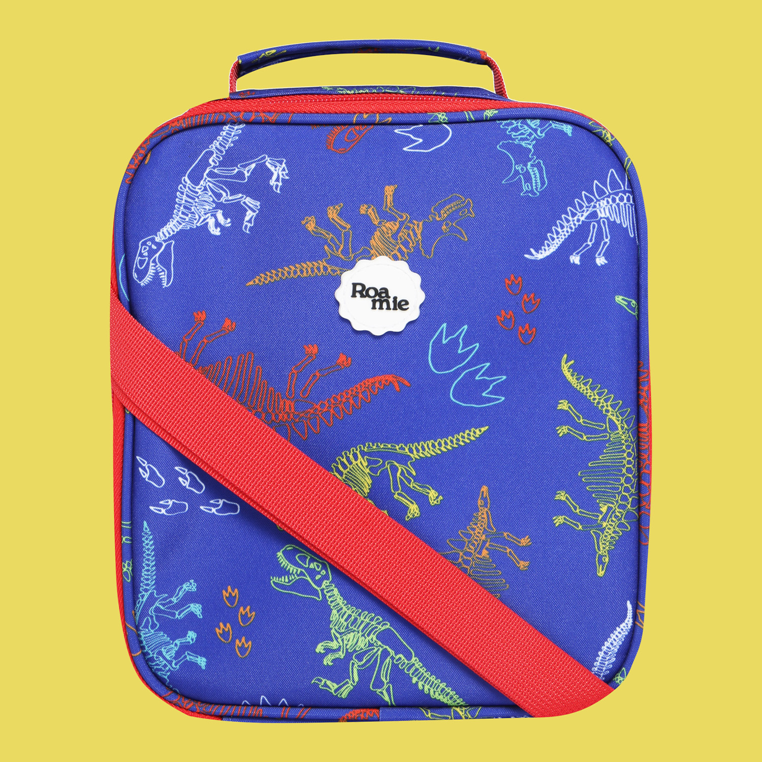 In front of a yellow background: a royal blue lunch bag with imagery of skeletal outlines of various dinosaur species in various colours amongst similar outlines of dinosaur tracks.