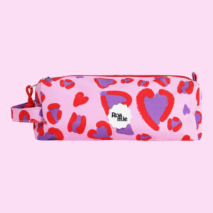 In front of a baby pink background: a baby pink pencil case with imagery of varying sized child-like drawings of hearts with a disjointed red outline and purple center.