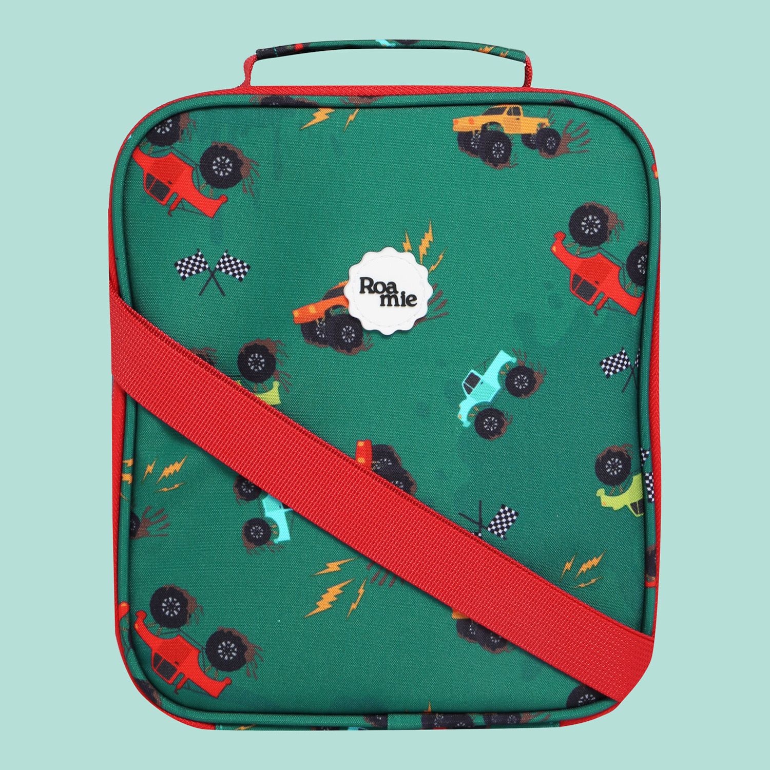 In front of a mint green background: an emerald green kids' lunch bag with imagery of various colours of monster trucks, racing flags, and faux oil marks.