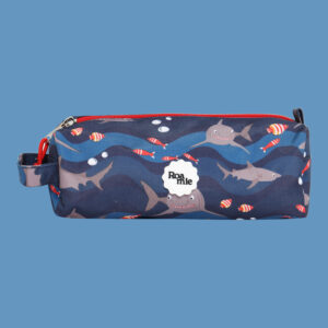 In front of a cornflower blue background: a kids' navy pencil case with imagery of sharks and various tropical fish in front of waves of various shades of blue.