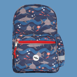 In front of a cornflower blue background: a kids' navy backpack with imagery of sharks and various tropical fish in front of waves of various shades of blue.